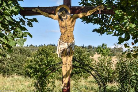 Drewniany krzyż Chrystusem z blachy w Dobromyślu