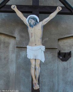 Drewniany krzyż przydrożny z Chrystusem wyciętym sylwetkowo z blachy