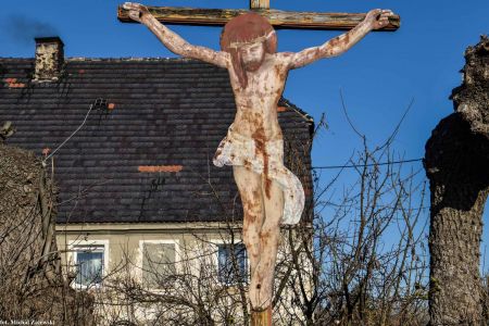 Drewniany krzyż przydrożny z blaszanym Chrystusem w Nowej Męcince