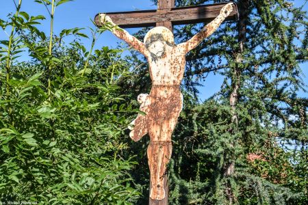 Chrystus z blachy na drewnianym krzyżu przydrożnym w Pakosławicach