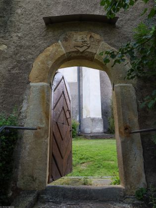 Boczna bramka na cmentarz kościelny z herbem Arnoszta z Pardubic