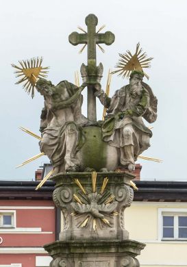 Trójca Święta koronująca Matkę Boską na kolumnie w Lądku-Zdroju, 1741 (fot. 2015). Pomnik określany jest w publikacjach jako Trójcy Świętej. W rzeczywistości jest to Koronacja Matki Boskiej. To oczywiście też przedstawienie Trójcy Świętej, ale w specyficznej treści oraz formie i jest odrębnym typem czy raczej podtypem, o czym się informuje zasadniczo w nazwie (Koronacja Maryi i podobne), ale nie tym wypadku. Może należy to wiązać z koncepcją autora rzeźby Michała Klahra, który nie to że kamufluje scenę koronacji, ale przedstawia w taki sposób, że aby ją odczytać, trzeba spojrzeć na pomnik uważnie. Efekt jest trochę zabawny. Otóż Bóg Ojciec i Jezus trzymają koronę i przygotowują się do jej zrzucenia na głowę Maryi z dosyć dużej wysokości. Zafrapowana mina Jezusa, celującego uważnie mającą spać na głowę Matki koroną, powoduje wręcz możliwość komicznego odczytania sceny.