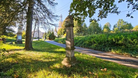 Marczów, pow. lwówecki. Kapliczka przy podejściu do kościoła Na cokole data 1686. Na kostkowej głowicy są z dwóch stron płaskorzeźby: po jednej stronie Pieta, po przeciwnej krucyfiks.