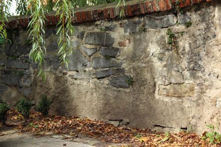 Wierzbice, pow. wrocławski, gm. Kobierzyce; granitowy krzyż wmurowany poziomo w mur cmentarza kościelnego