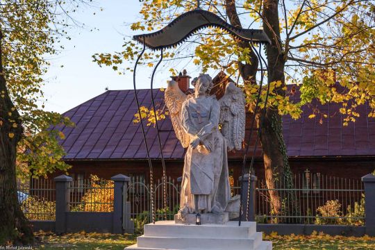 Tomaszów Lubelski. Anioł w trynitarskim habicie z charakterystycznym czerwono-niebieskim krzyżem na białym szkaplerzu. Zakon zajmował się wykupem chrześcijan z niewoli, dlatego anioł ma symbolicznie związane ręce. Depcze też wykrzywioną twarz, symbolizującą demony. Ok. poł. XVIII w.